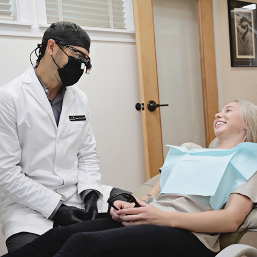 Dentist with mask talking to patient