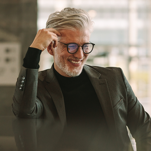 Man with glasses and leather jacket smiling