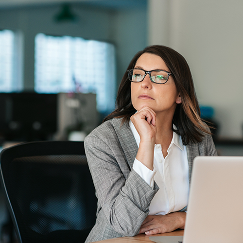 Business woman with glasses sitting at laptop