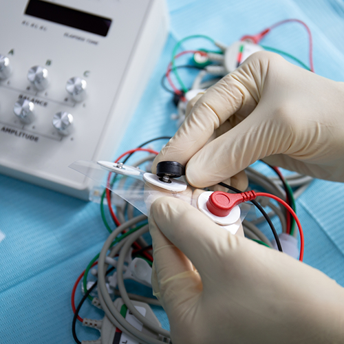 Gloved hands working with TENS machine