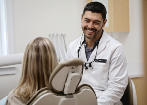 Dentist talking to female dental patient and smiling