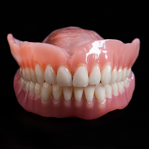 Close up of full dentures on black background