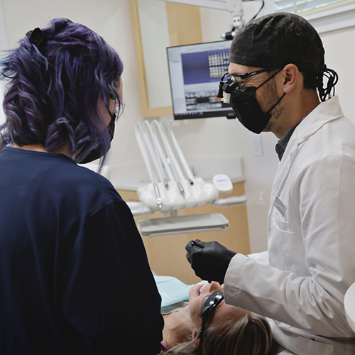 Dentist and dental team member treating patient