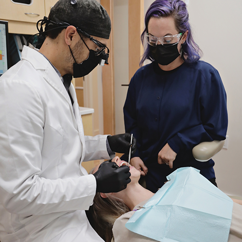 Dentist and team member treating patient