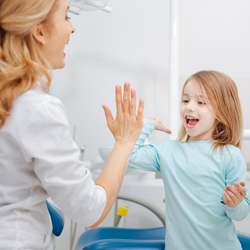 Little girl giving dentist high five